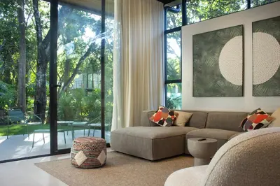 a living room with a couch and a large window at D'Palm Villas in Puntarenas
