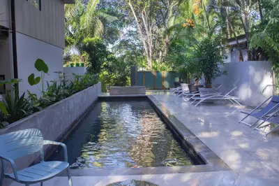 a pool of water with chairs in a building at D'Palm Villas in Puntarenas