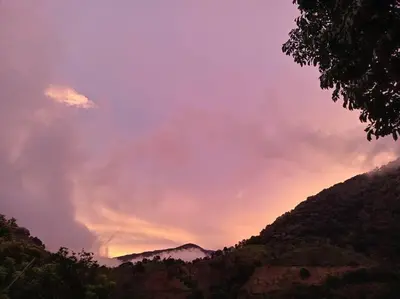 a sunset over a mountain range with the sky at Cabaña Paraíso Verde in Providencia