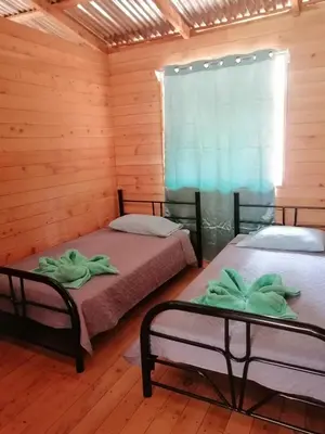 two beds in a room with a window at Cabaña Paraíso Verde in Providencia