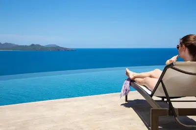 a woman sitting in a chair by the water at 360 Splendor - Ocean-View Condo #204 in Luxury Flamingo-Complex in Playa Flamingo