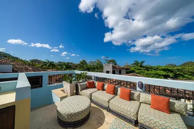 a balcony with a couch and a table and chairs at Casa Cazenovia - 3BR home, astonishing rooftop terrace in Las Catalinas in Playa Danta