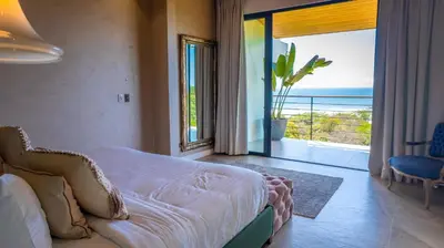 a bedroom with a bed and a view of the ocean at Grand Oceanview Villas - Casa Aria and Casa Magnifique in Santa Teresa Beach