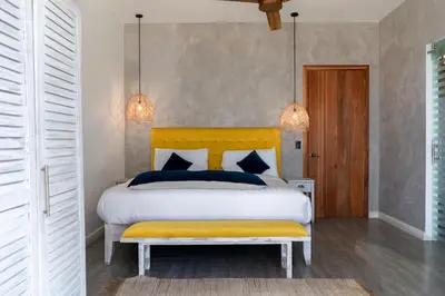 a bedroom with a large bed with a yellow headboard at Grand Oceanview Villas - Casa Aria and Casa Magnifique in Santa Teresa Beach