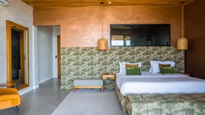 a bedroom with a large bed with green pillows at Grand Oceanview Villas - Casa Aria and Casa Magnifique in Santa Teresa Beach