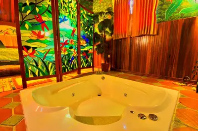a large bath tub in a room with a painting at Hotel La Mansion Inn Arenal in Nuevo Arenal