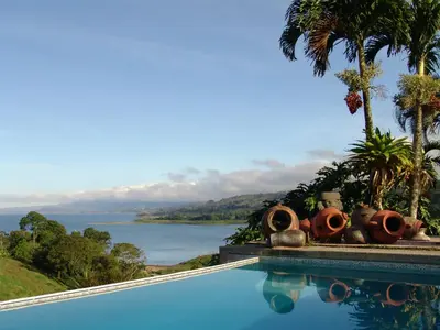 a swimming pool with a view of a body of water at Hotel La Mansion Inn Arenal in Nuevo Arenal