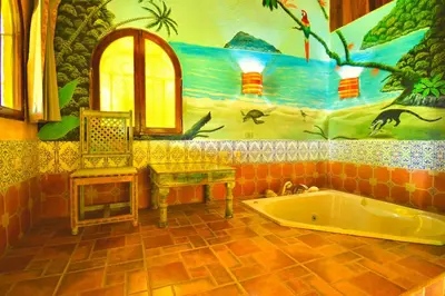 a bathroom with a tub and a painting on the wall at Hotel La Mansion Inn Arenal in Nuevo Arenal