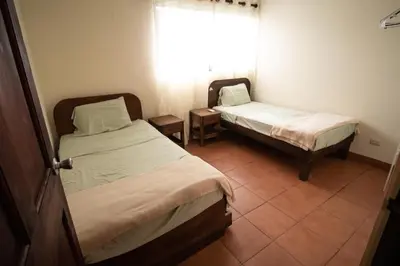 a room with two beds and a window at Anona Guesthouse in Playa Hermosa