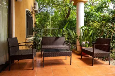 three chairs and a table on a patio at Anona Guesthouse in Playa Hermosa