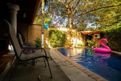 a swimming pool with a pink flamingo in the water at Anona Guesthouse in Playa Hermosa