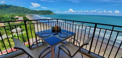 a table and chairs on a balcony with the beach at SecretJaco - Luxury Beach Front Penthouse with Pool & Jacuzzi in Jacó