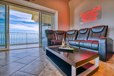 a living room with a leather couch and a table at SecretJaco - Luxury Beach Front Penthouse with Pool & Jacuzzi in Jacó