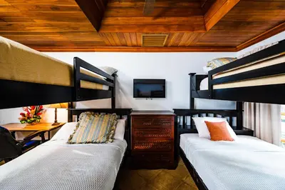 two bunk beds in a room with a tv at Casa Arrecife - 5bdr Beachfront Villa - Ethereal sunsets in Tamarindo
