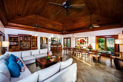 a living room with white couches and a dining room at Casa Arrecife - 5bdr Beachfront Villa - Ethereal sunsets in Tamarindo