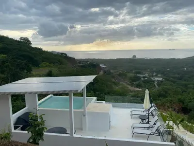 a house with a swimming pool and a view of the ocean at CASA AYLA B - charming 2BR ocean view condo in Flamingo in Playa Flamingo