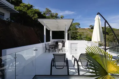 a patio with chairs and a table and an umbrella at CASA AYLA B - charming 2BR ocean view condo in Flamingo in Playa Flamingo