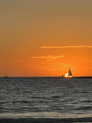 a sail boat in the ocean at sunset at AYLA C - new, cozy Ocean view Studio in Flamingo in Playa Flamingo