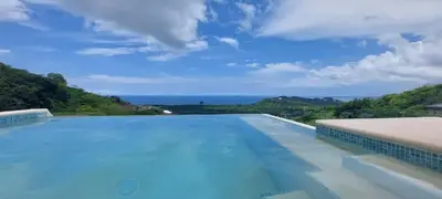 a large swimming pool with a view of the ocean at AYLA D - lovely Ocean view Studio in Flamingo in Playa Flamingo