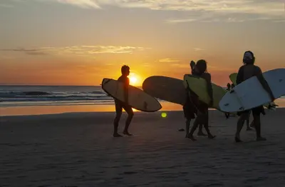 a group of people walking on the beach with their surfboards at AYLA D - lovely Ocean view Studio in Flamingo in Playa Flamingo