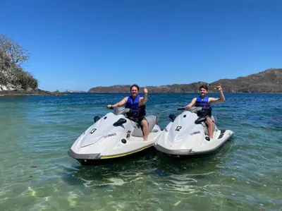 two people are riding on motorcycles in the water at AYLA D - lovely Ocean view Studio in Flamingo in Playa Flamingo