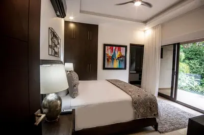 a bedroom with a bed with a lamp and a window at Casa Mar CR in Herradura