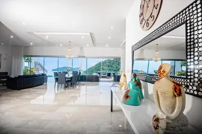a living room with a clock and vases on a table at Casa Mar CR in Herradura