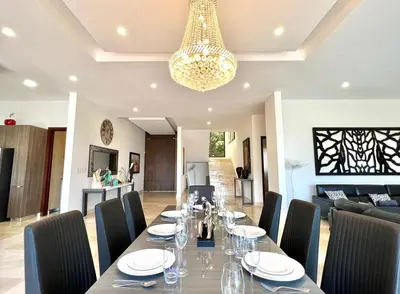 a dining room with a table and chairs and a chandelier at Casa Mar CR in Herradura