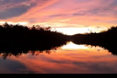 a sunset over a lake with the reflection of the sky at Casa Chazu in Quepos