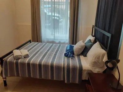 a bed with a blue and white striped sheets and pillows at Casa Chazu in Quepos