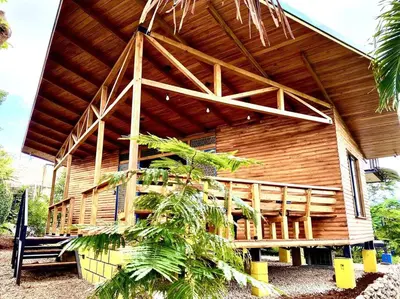 a large wooden house with a wooden roof at Hoja Azul - Sustainable teak modern cabin in Hojancha in Hojancha
