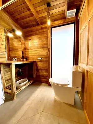 a bathroom with a tub and a toilet in a room at Hoja Azul - Sustainable teak modern cabin in Hojancha in Hojancha