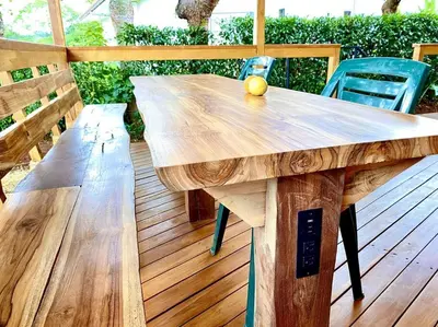a wooden table and chairs on a wooden deck at Hoja Azul - Sustainable teak modern cabin in Hojancha in Hojancha
