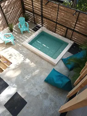 a swimming pool with a blue chair and a bench at Casa MONO in Santa Teresa Beach