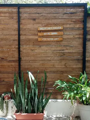 a sign on a wooden wall with some plants at Casa MONO in Santa Teresa Beach
