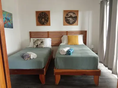 two beds sitting next to each other in a room at Casa CIELO in Santa Teresa Beach