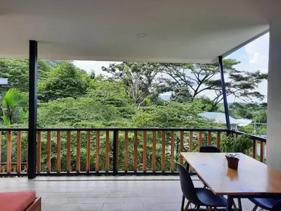 a wooden table and chairs on a balcony with a view at Casa CIELO in Santa Teresa Beach