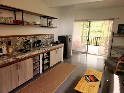 a kitchen with a counter and a refrigerator at Casa CIELO in Santa Teresa Beach