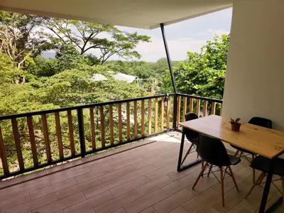 a balcony with a wooden table and chairs on it at Casa CIELO in Santa Teresa Beach