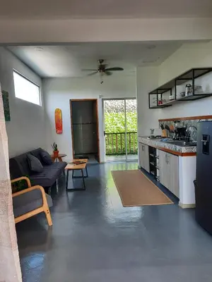 a living room with a couch and a kitchen at Casa CIELO in Santa Teresa Beach