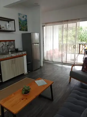 a living room with a table and a kitchen at Casa CIELO in Santa Teresa Beach