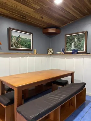 a wooden table and benches in a room at Monteverde Guesthouse in Monteverde Costa Rica