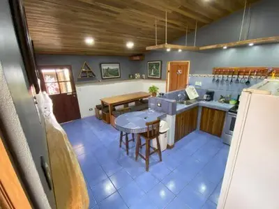 a kitchen with a table and a kitchen with a counter at Monteverde Guesthouse in Monteverde Costa Rica