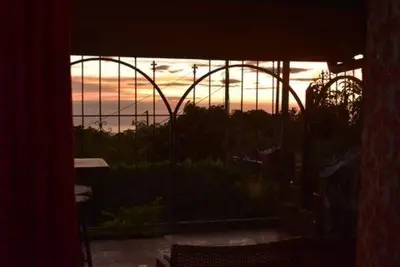 a view of the sunset from a room with a window at Monteverde Guesthouse in Monteverde Costa Rica
