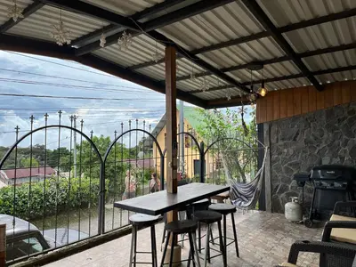 a patio with a table and chairs and a balcony at Monteverde Guesthouse in Monteverde Costa Rica