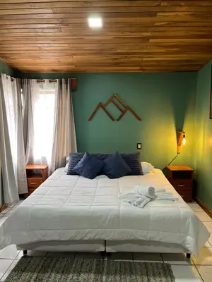 a bedroom with a large bed with a wooden ceiling at Monteverde Guesthouse in Monteverde Costa Rica