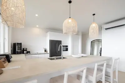 a kitchen with white walls and a large island with chairs at CASA AYLA A - stunning 5BR Ocean view house & infinity pool in Flamingo in Playa Flamingo
