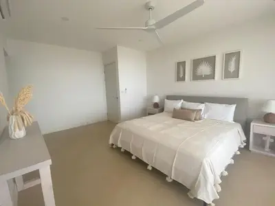 a white bedroom with a bed and a ceiling fan at CASA AYLA A - stunning 5BR Ocean view house & infinity pool in Flamingo in Playa Flamingo