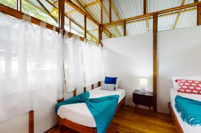 a bedroom with two beds and a window at Casa Beluga in Uvita