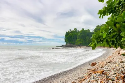 a pebble beach in front of the ocean at Casa Beluga in Uvita